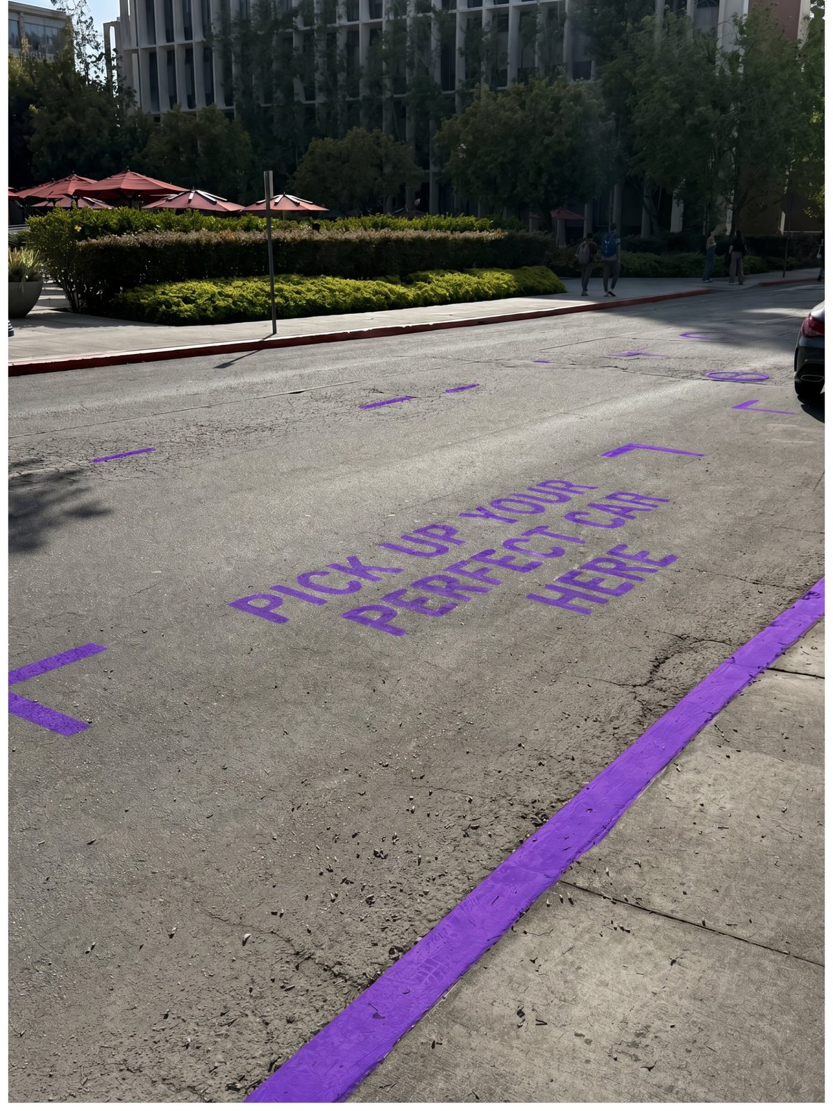 Purple pickup spot signage on USC campus road
